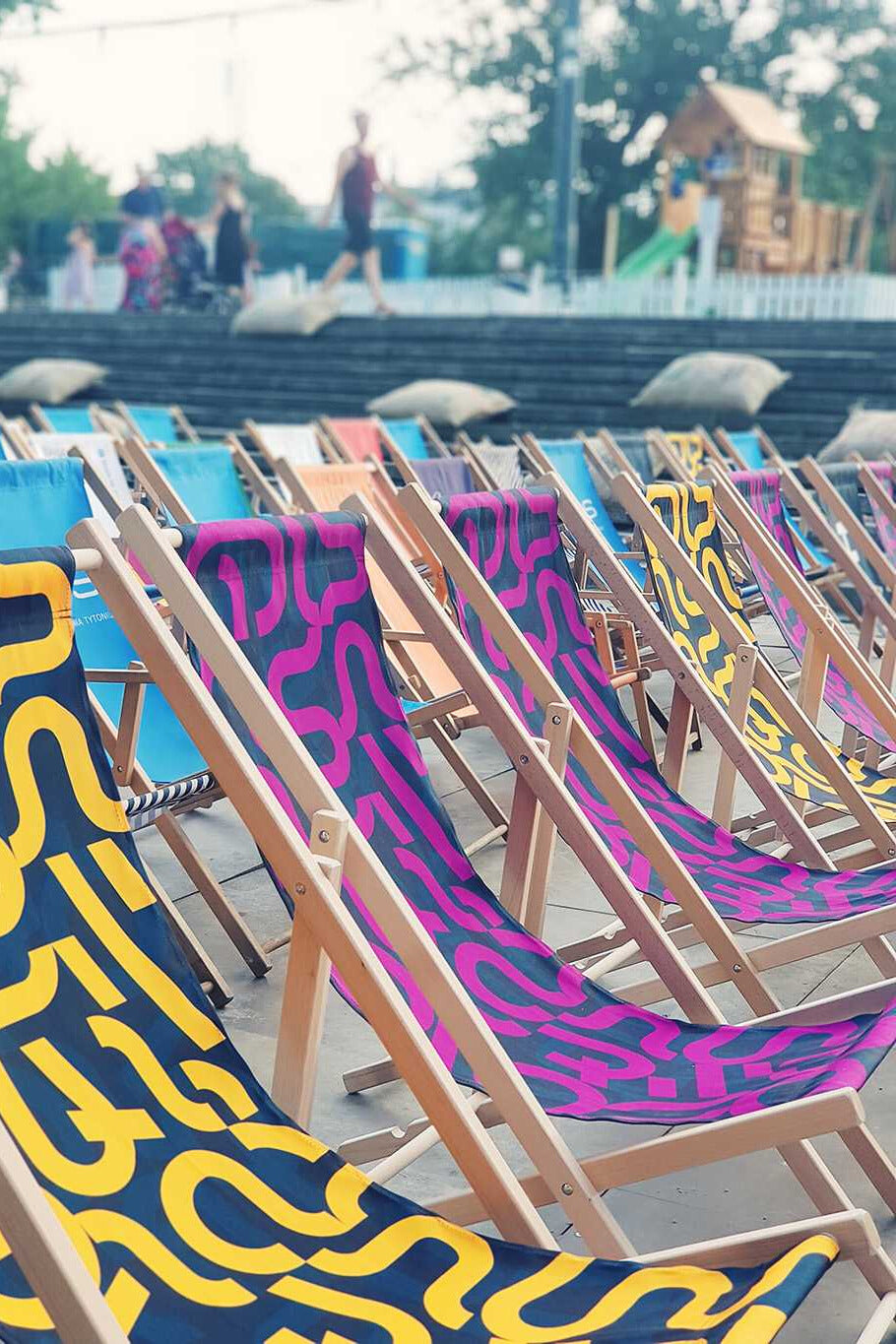 Mehrere bedruckte Liegestühle von hi5branding als markantes Gestaltungselement bei Veranstaltung im Freien